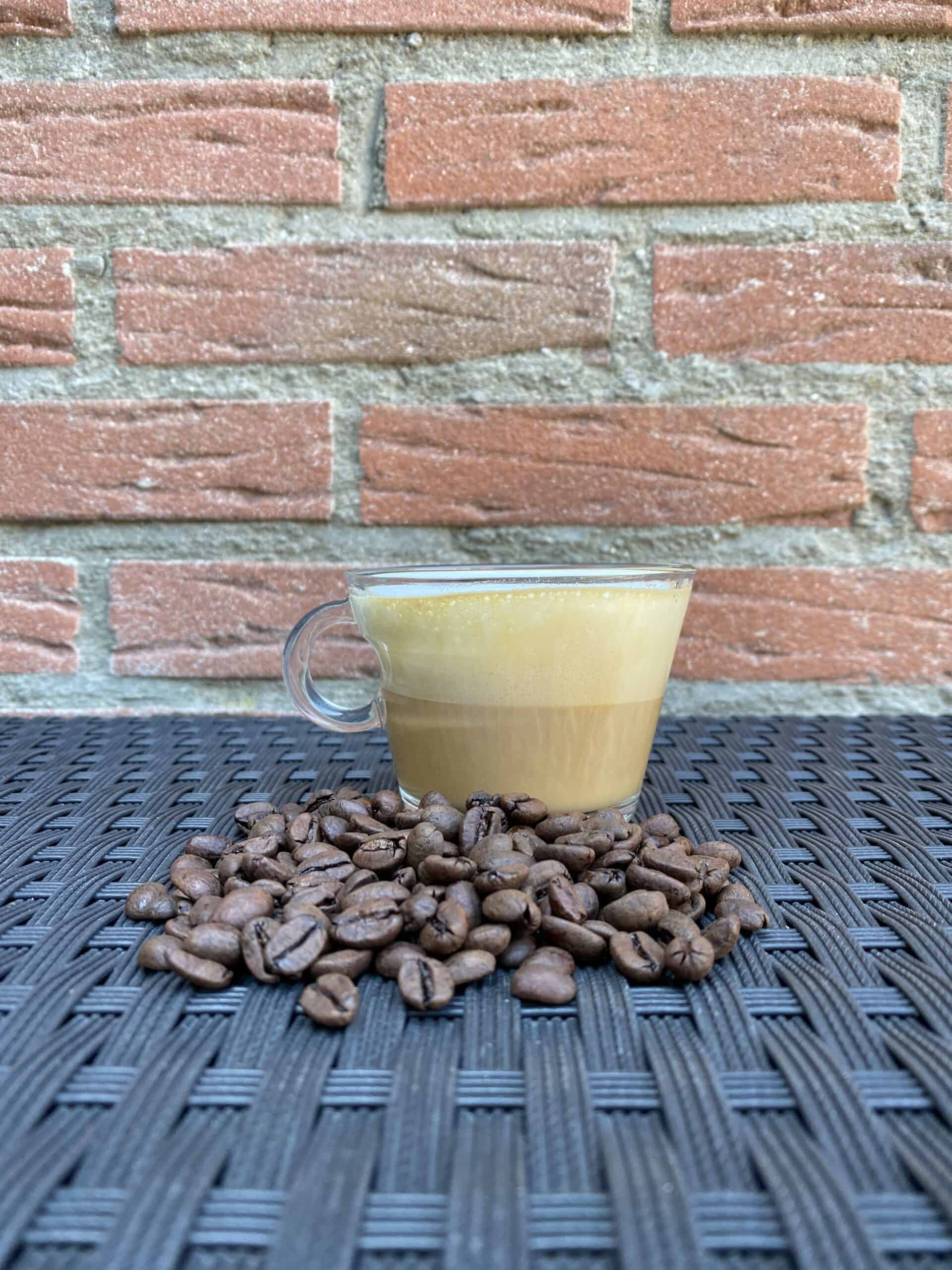 A cappuccino with coffee beans in the front.