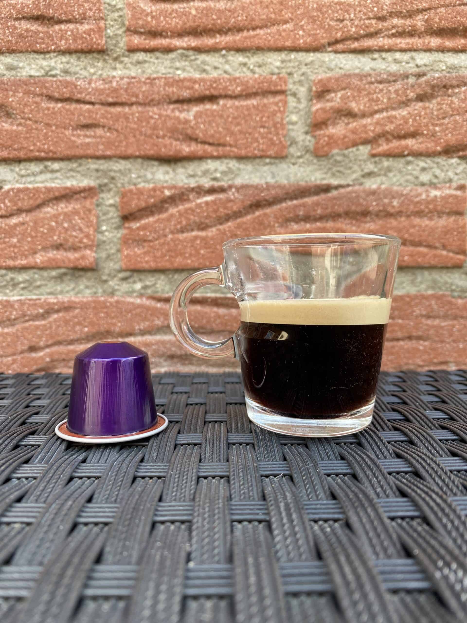 Brewed Nespresso Arpeggio next to its Nespresso pod.